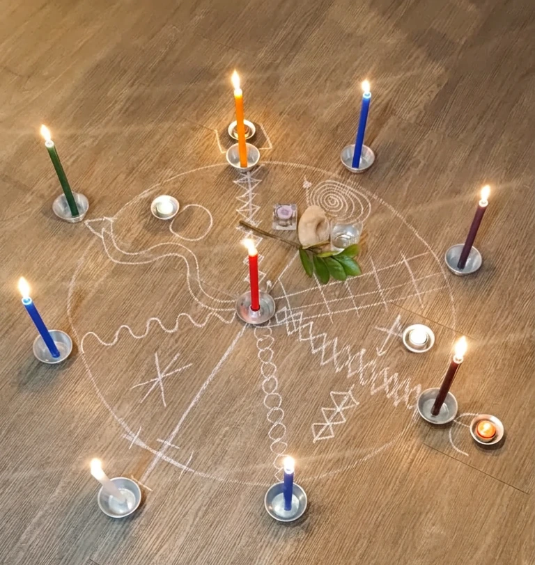 Velas acesas dispostas em círculo sobre o piso, formando uma mandala